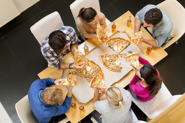 Group of young people eating pizza and drinking cider Stock photo © boggy