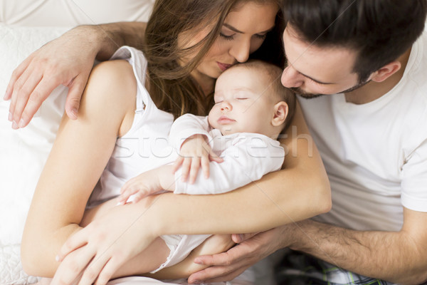 Portrait of happy cheerful family sitting on the bed at home Stock photo © boggy