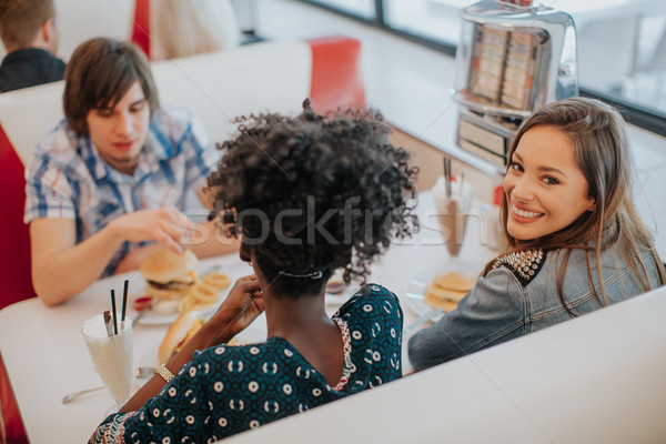 Young multiracial friends enjoying in the diner Stock photo © boggy