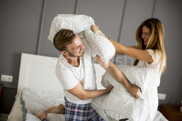 Bataille d'oreillers lit maison couple [[stock_photo]] © boggy