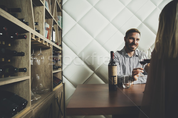 Handsome young couple on the date sitting by table in wine bar Stock photo © boggy