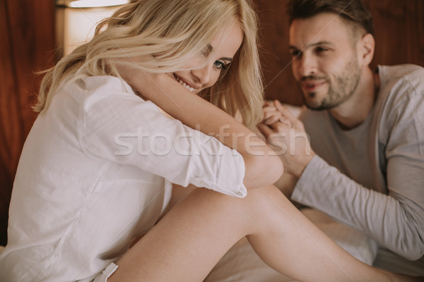 Young adult heterosexual couple on bed in bedroom Stock photo © boggy