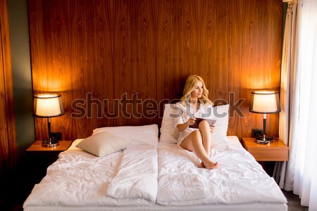 Jungen blonde Frau Sitzung Bett Zimmer Aussehen Stock foto © boggy