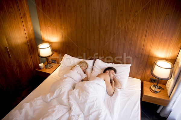 Young adult heterosexual couple on bed in bedroom Stock photo © boggy