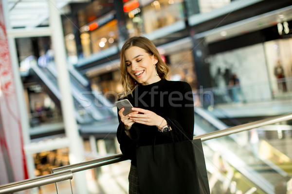 Guardando cellulare shopping centro ritratto Foto d'archivio © boggy