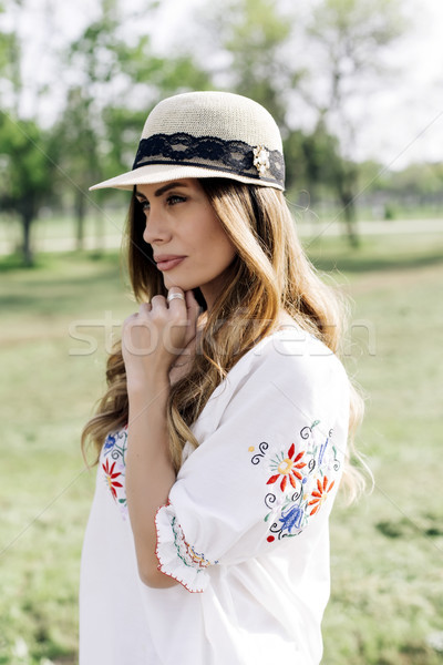Portrait of a beautiful elegant woman with hat posing in the par Stock photo © boggy