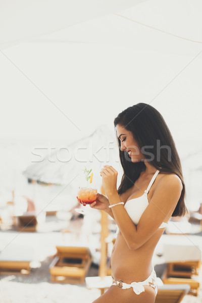 Young woman with coctail on the beach at summer Stock photo © boggy