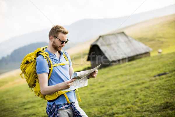 Young redhair man on mountain hiking holding a map Stock photo © boggy