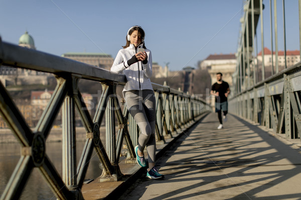 Woman on the bridge making a pause after the exercise Stock photo © boggy