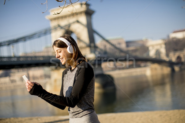 Woman making a pause after the exercise and using mobile phone Stock photo © boggy