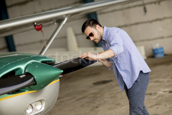 Handsome young pilot checking his ultralight airplane before fli Stock photo © boggy