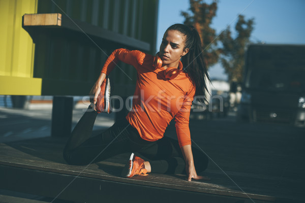 Young woman exercises on the promenade after running Stock photo © boggy