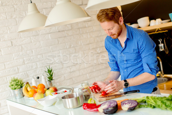 Stock photo: Redhair young man cooking food