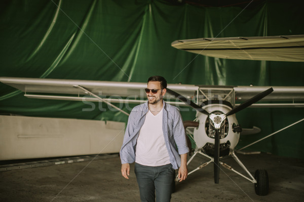 Young man in the airplane hangar Stock photo © boggy