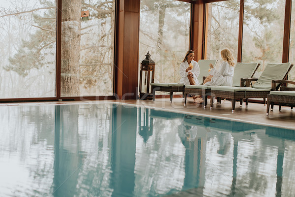 Cheerful women in bathrobes drinking juice in spa center Stock photo © boggy