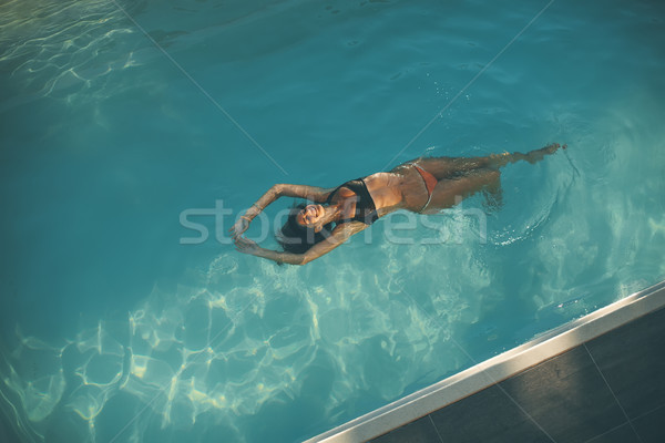 Young woman floating in the pool Stock photo © boggy