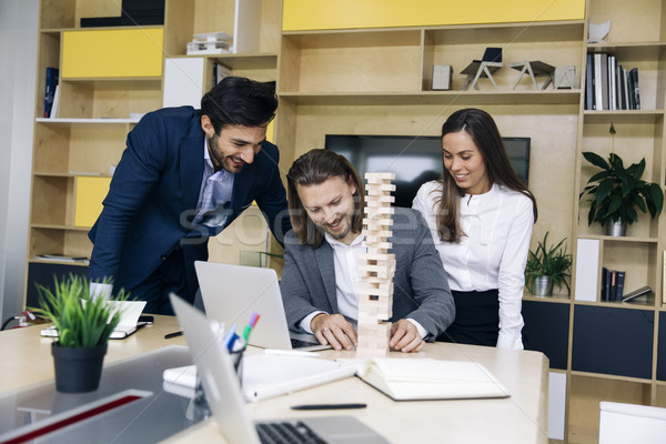 Team of young business people build a wooden construction Stock photo © boggy