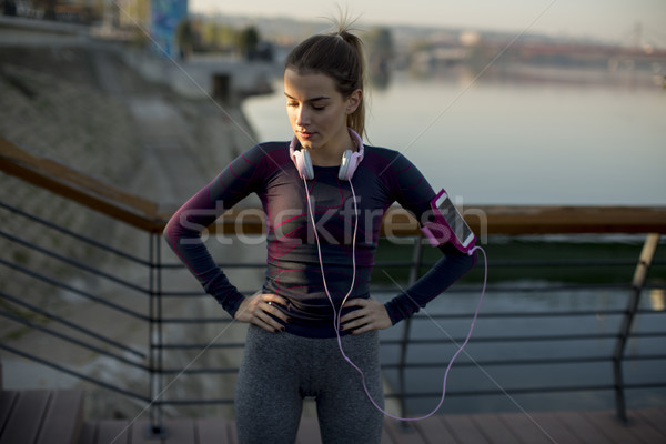 Young attractive female  runner taking break after jogging outdo Stock photo © boggy