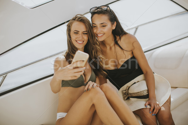 Two pretty young women taking selfie on vacation at the yacht Stock photo © boggy