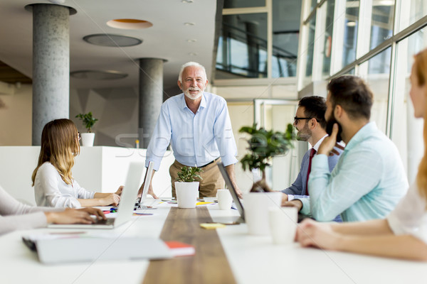 Stock photo: Senior boss holds a meeting for younger colleagues