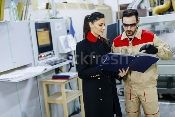 Young woman controlling process in the factory with male worker Stock photo © boggy
