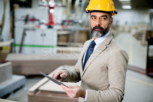 Middle-aged businessman with digital ta in factory Stock photo © boggy