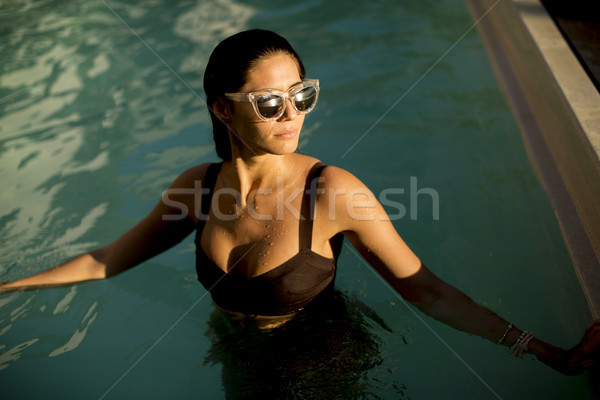 Pretty young woman relaxcing on the poolside Stock photo © boggy