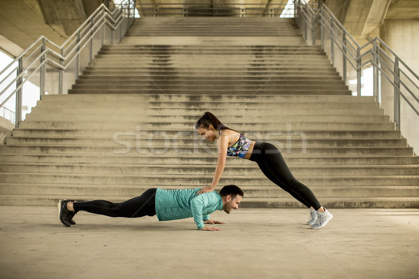 Stock photo: Athletic young couple doing stretching  exercises together