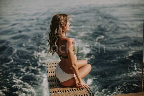 Young attractive woman sitting on  luxury yacht floating at sea Stock photo © boggy