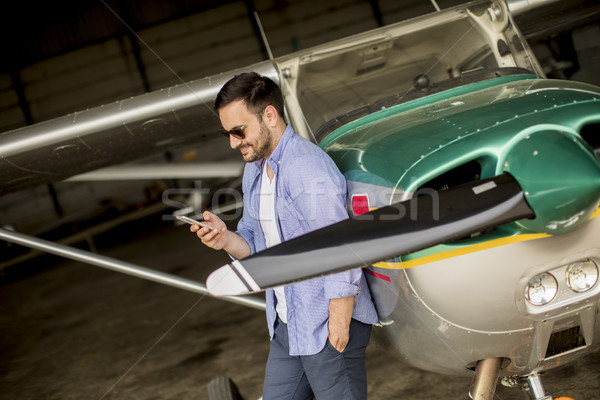 Bonito jovem piloto avião telefone móvel tecnologia Foto stock © boggy