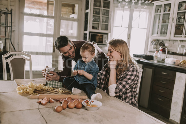 Happy family making pasta in the kitchen at home Stock photo © boggy