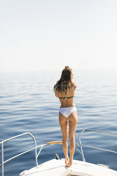 Young attractive woman poses on  luxury yacht floating at sea Stock photo © boggy