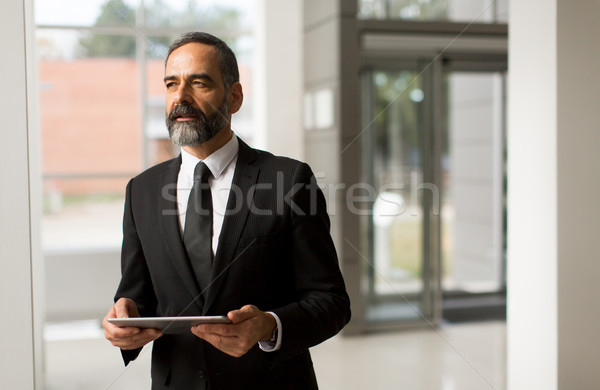 Middle age businessman with tablet in the office Stock photo © boggy