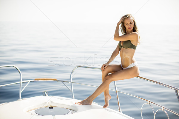 Young attractive woman poses on  luxury yacht floating on sea Stock photo © boggy