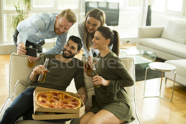 Young people eating pizza, drinking cider and taking selfie in t Stock photo © boggy