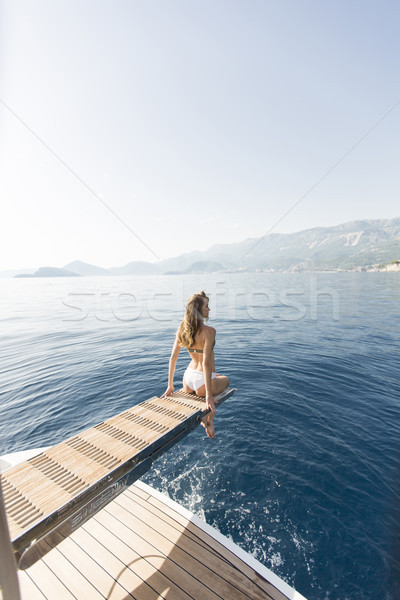 Young attractive woman sitting on  luxury yacht floating at sea Stock photo © boggy