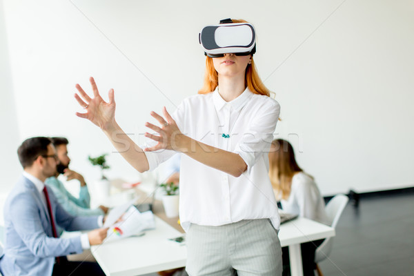 Young woman using virtual reality simulator in the office Stock photo © boggy