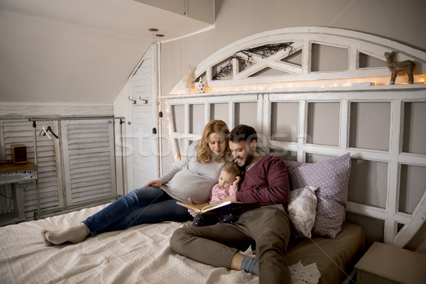 Young parent reading book to cute little girl in bed Stock photo © boggy