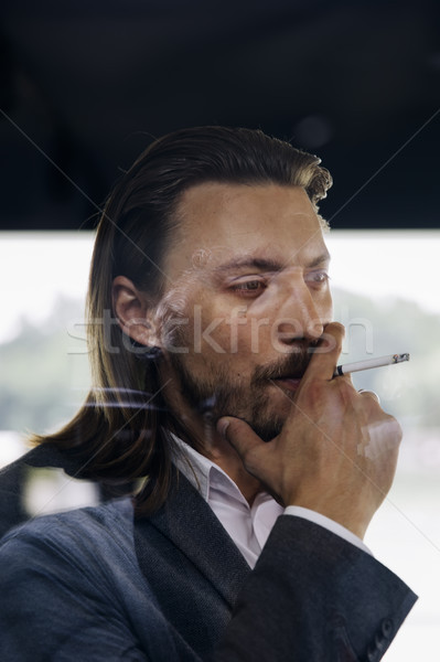 Side view at young businessman enjoying his cigar Stock photo © boggy