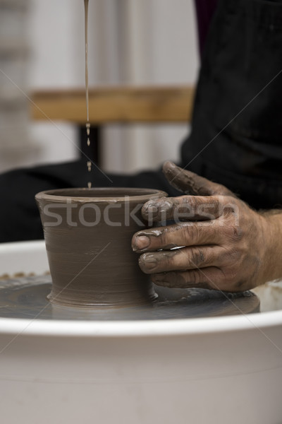 Artist makes clay pottery on a spin wheel Stock photo © boggy