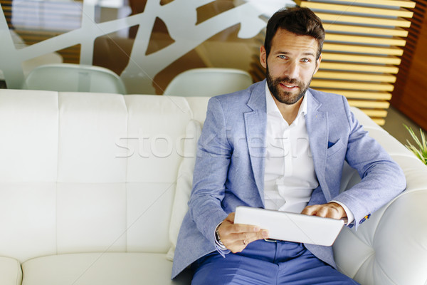 Young businessman touching digital tablet and checking data Stock photo © boggy