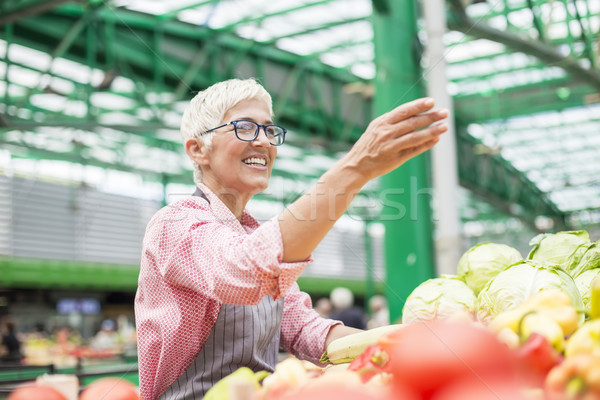 Senior woman sells vegetable on market Stock photo © boggy