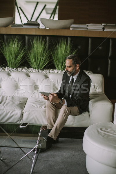 Confident senior businessman with digital tablet Stock photo © boggy