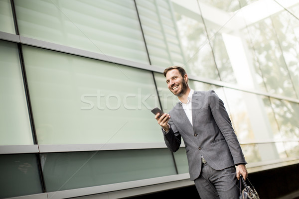 Knap jonge zakenman mobiele telefoon kantoor bouwen Stockfoto © boggy