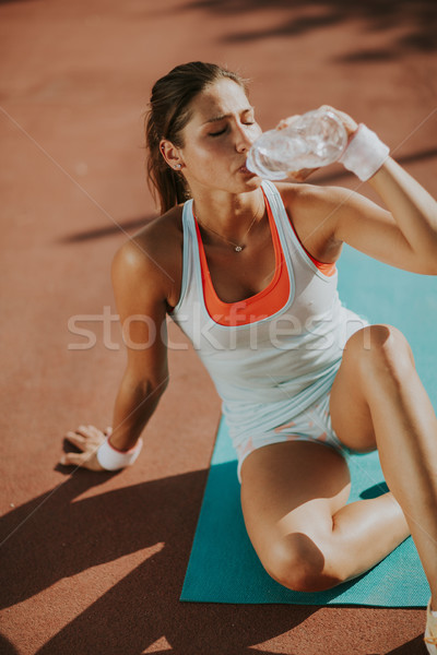 Mujer de la aptitud agua potable ejecutando sediento femenino corredor Foto stock © boggy