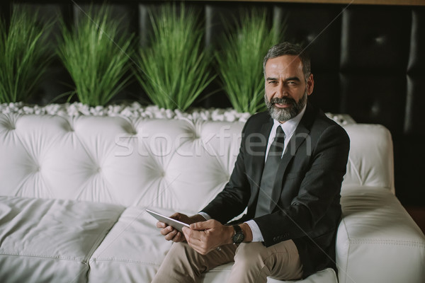 Confident senior businessman with digital tablet Stock photo © boggy