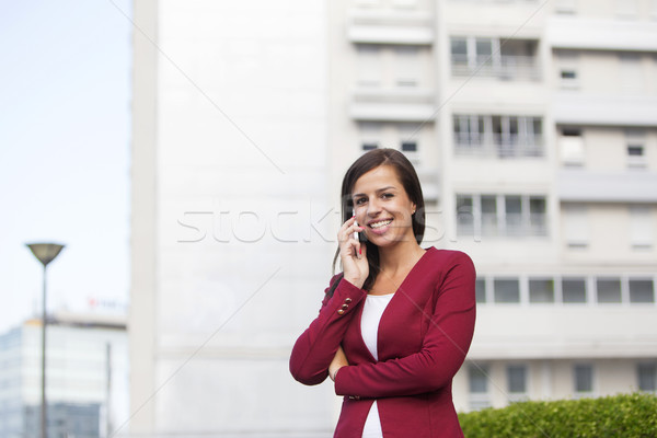 Young businesswoman in red blazer talking over the mobile phone Stock photo © boggy
