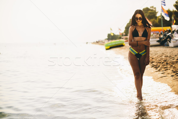 Fit and sporty woman in a swimsuit relaxing on a beach at summer Stock photo © boggy