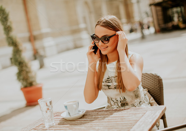 Stock photo: Pretty young woman using mobile phone in the cafe