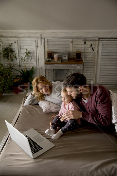 счастливая семья Ложь кровать смотрят что-то ноутбука Сток-фото © boggy